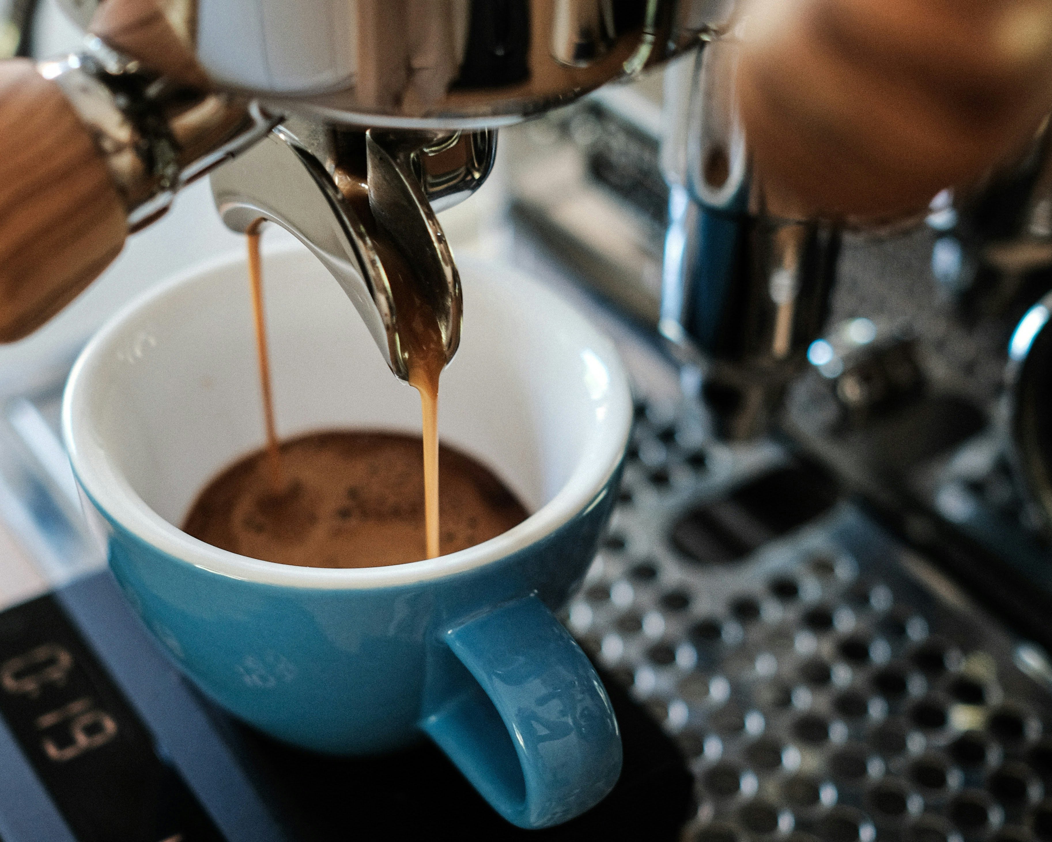 Specialty espresso coffee pulling into a teal cup on an espresso machine — Wonder Waves Coffee beans roasted to order
