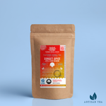 Sunset Spice Apple Cider Rooibos tea packaging with a rustic kraft pouch design, featuring a vivid red-orange ocean-themed label with a sunset illustration, flavor descriptors, and the ‘Artisan Tea’ label. Includes branding for Wonder Waves Coffee, highlighting its spicy, sweet, caffeine-free blend and eco-friendly packaging.