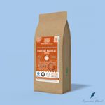 Hightide Harvest pumpkin whole bean coffee packaging with a rustic kraft bag design, featuring a cool blue ocean-themed label with a pumpkin illustration, coffee roast icons, and the ‘Signature Blend’ label. Includes branding for Wonder Waves Coffee, emphasizing its medium roast and eco-friendly packaging.