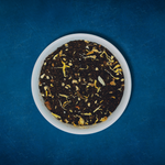Close-up of Sassy Seagull loose-leaf masala chai black tea in a white bowl on a blue background by Wonder Waves Coffee