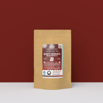 Mighty Monarch English Breakfast Tea packaging with a rustic kraft pouch design, featuring a maroon ocean-themed label with an illustration of a galleon, flavor descriptors, and the ‘Artisan Tea’ label. Includes branding for Wonder Waves Coffee, emphasizing its robust, malty, and brisk profile and eco-friendly packaging.