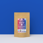 Horizon Hues Hibiscus Berry Rooibos tea packaging with a rustic kraft pouch design, featuring a radiant magenta-to-indigo ocean-themed label with wave iconography, flavor descriptors, and the ‘Artisan Tea’ label. Includes branding for Wonder Waves Coffee, showcasing its fruity, tangy, rounded, and caffeine-free character and eco-conscious packaging.