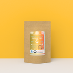 Tropical Tides Mango black tea packaging with a rustic kraft pouch design, featuring a golden-orange ocean-themed label with a hammock and palm tree illustration, flavor notes, and the ‘Artisan Tea’ label. Includes branding for Wonder Waves Coffee, highlighting its fruity, sweet, and lively character and sustainable packaging.