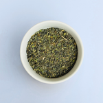 Close-up of Tangier Tingle loose-leaf Moroccan green tea in a white bowl on a white background by Wonder Waves Coffee