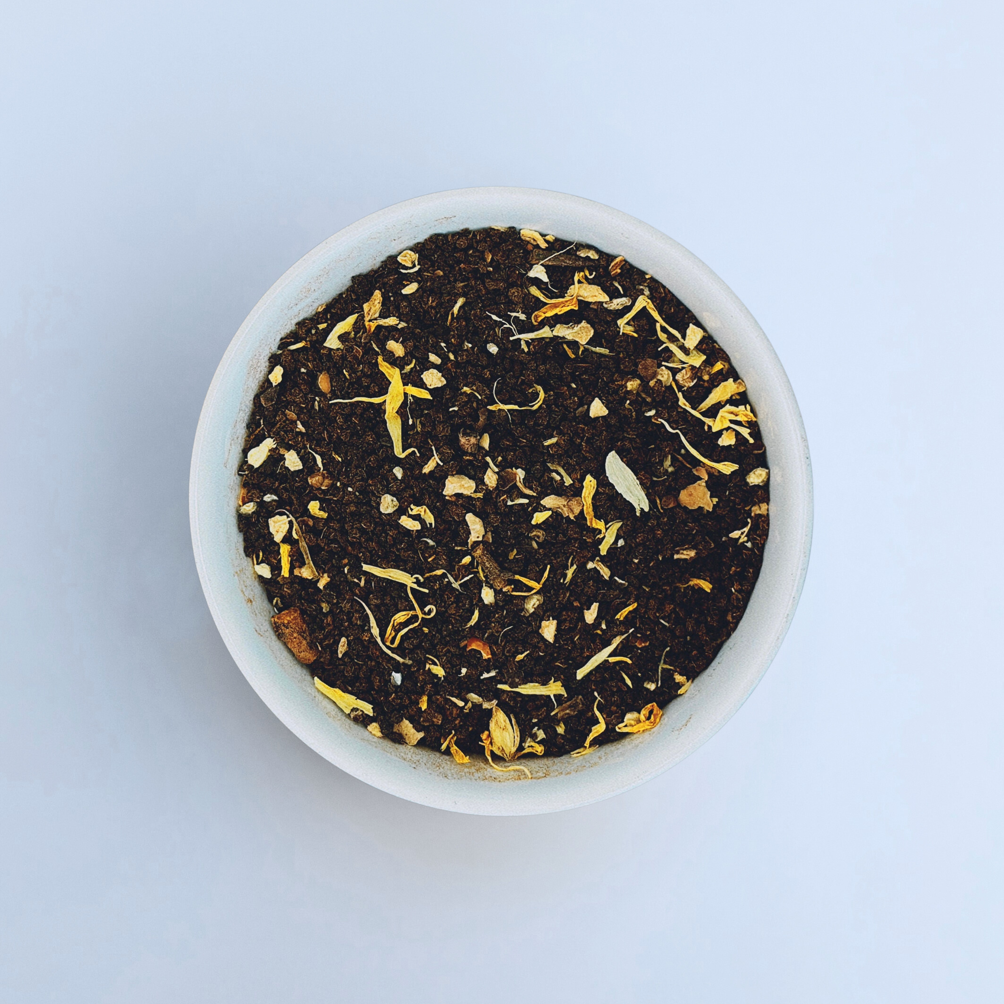 Close-up of Sassy Seagull loose-leaf masala chai black tea in a white bowl on a white background by Wonder Waves Coffee