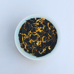 Close-up of Tropical Tides loose-leaf Mango black tea tea in a white bowl on a white background by Wonder Waves Coffee