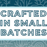 Text 'Crafted in Small Batches' on a white background, surrounded by a soft blue frame and a misty and deep blue coral-themed backdrop, highlighting the artisan and small-batch blending process for artisan tea
