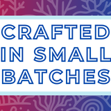 Text 'Crafted in Small Batches' on a white background, surrounded by a soft blue frame and a red and blue coral-themed backdrop, highlighting the artisan and small-batch blending process for artisan tea