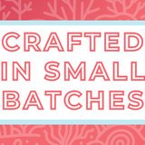 Text 'Crafted in Small Batches' on a white background, surrounded by a soft blue frame and a coral-pink and coral-themed backdrop, highlighting the artisan and small-batch blending process for artisan tea