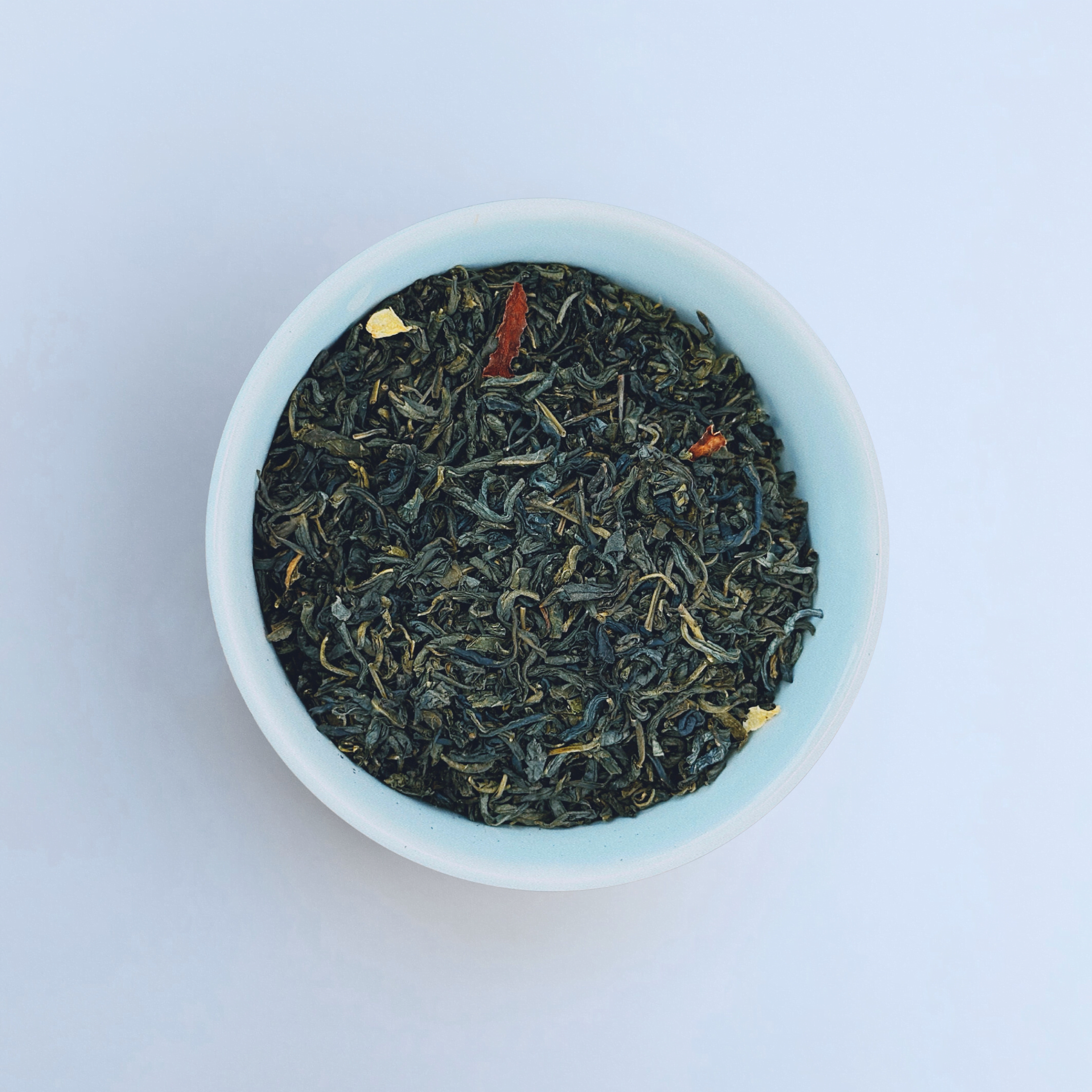 Gulfstream Glow Jasmine Green loose leaf green tea in white bowl close-up by Wonder Waves Coffee featuring delicate floral jasmine aroma and smooth green tea body