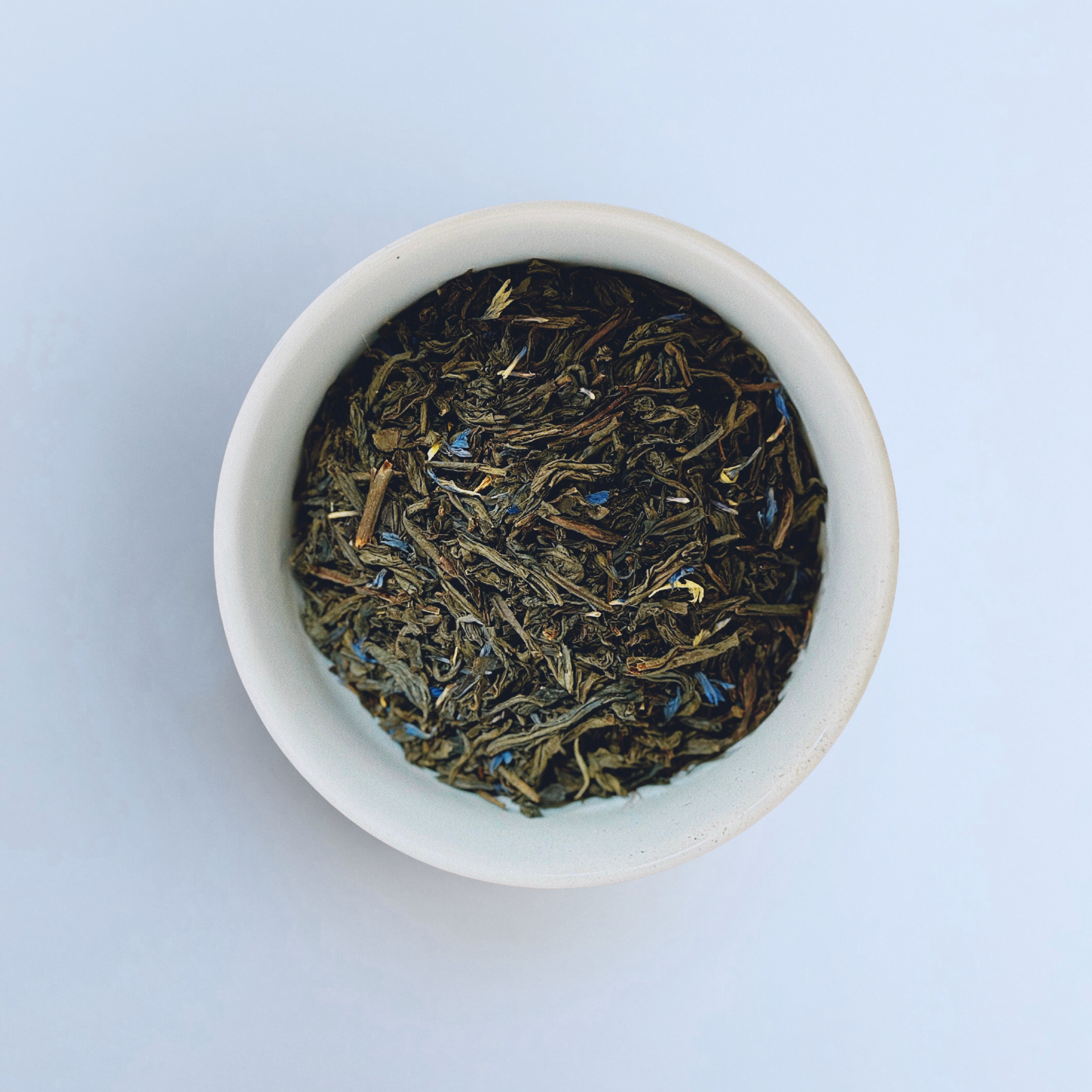Harbor Haze Earl Grey loose leaf black tea in white bowl close-up by Wonder Waves Coffee featuring bright bergamot citrus and aromatic black tea notes