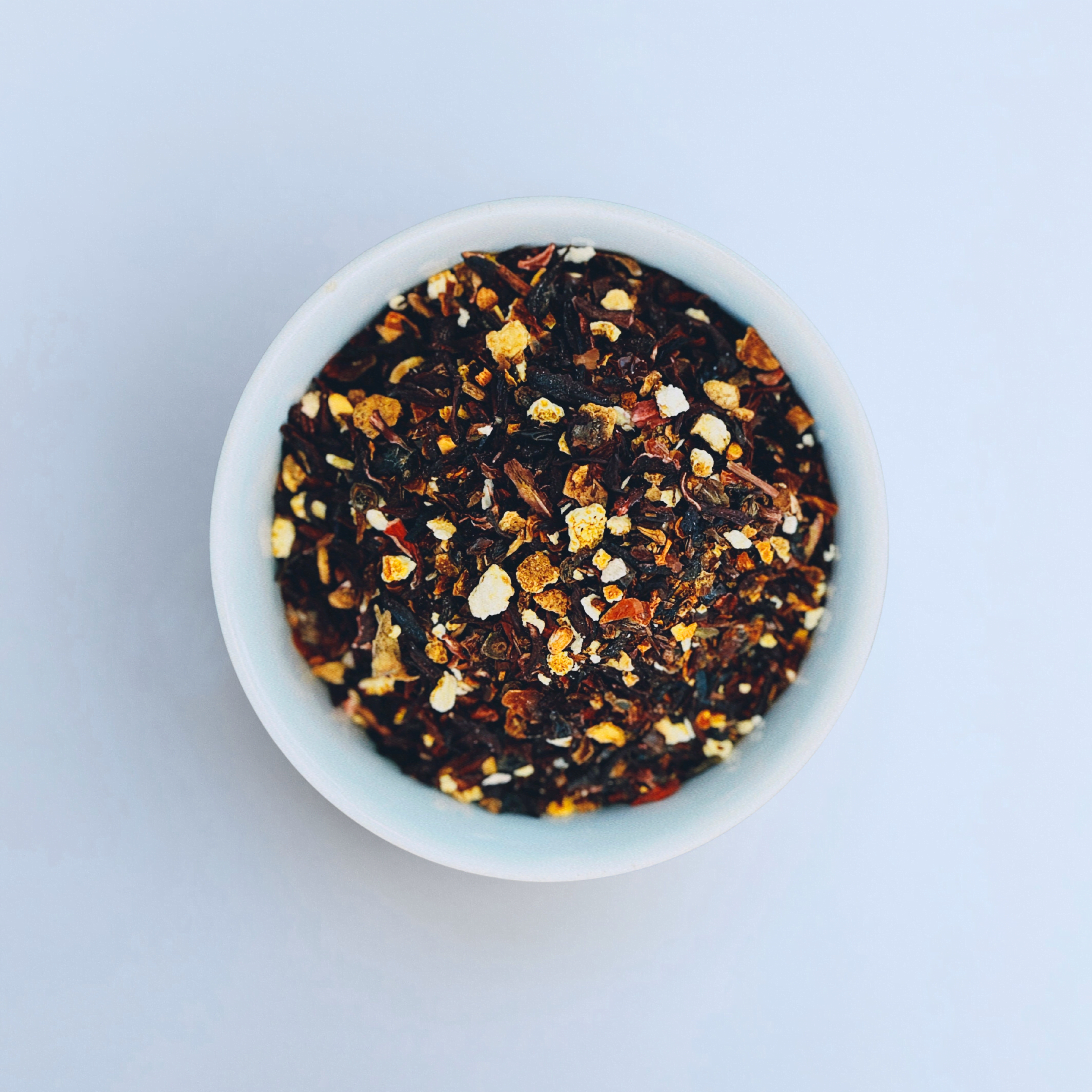 Horizon Hues Hibiscus Berry Rooibos loose leaf herbal tea in white bowl close-up by Wonder Waves Coffee featuring sweet-tart hibiscus and bright berry notes