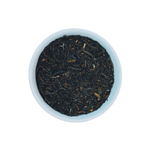 Mighty Monarch English Breakfast loose leaf black tea in white bowl close-up by Wonder Waves Coffee featuring a robust, malty and brisk flavor profile