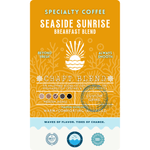 The product label for Wonder Waves Coffee Seaside Sunrise Breakfast Blend. A bright orange and yellow design featuring a sun rising over waves, identifying it as a medium roast craft blend from Central and South America with warm, comforting, and balanced flavor highlights.