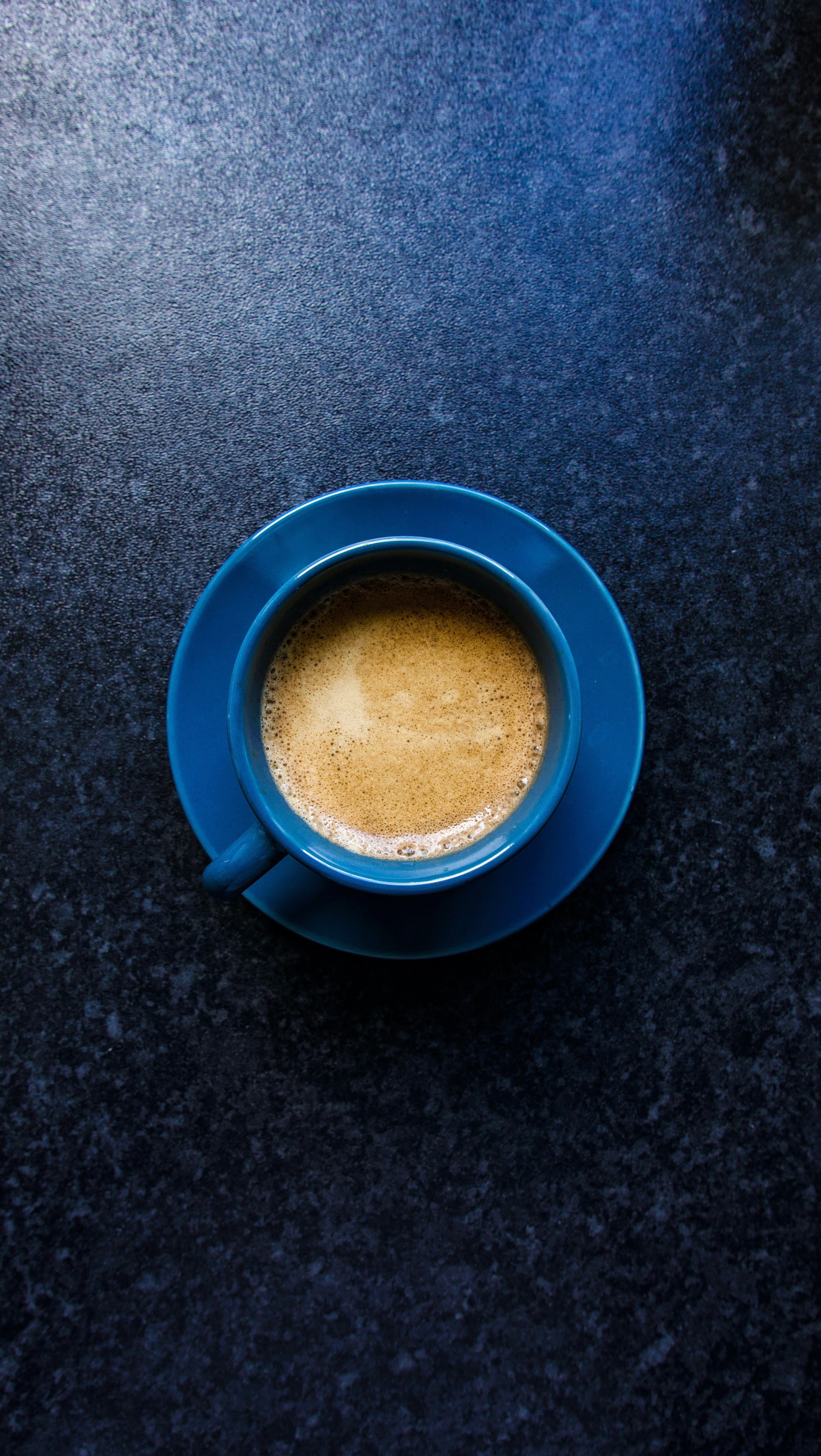 Overhead view of a freshly pulled specialty espresso with golden crema in a blue cup and saucer, representing Wonder Waves Coffee's ocean-inspired brand aesthetic