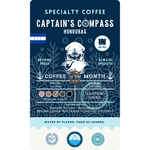 Product label for Wonder Waves Coffee "Captain's Compass" Coffee of the Month featuring Honduras La Paz beans. The navy blue label shows a white sea captain illustration and the Honduran flag. It is a medium roast with medium acidity and tasting notes of brown sugar, nectarine, and toasted coconut, grown at 1,510 MASL.
