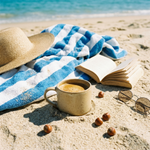Wonder WavesCoffee hazelnut coffee in a ceramic mug on sandy beach with a book, sunglasses and hazelnuts, evoking the warm, smooth and slightly sweet profile of Seabreeze Sizzle flavored coffee.