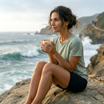 Woman enjoying coffee on coastal cliffs overlooking the ocean, reflecting the smooth, refined and balanced character of Wonder Waves Coffee Pacific Pearl Peruvian single origin coffee.